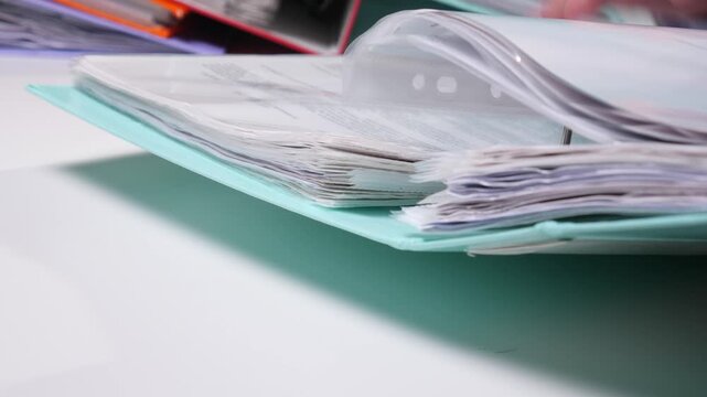 Ring binder with numerous organized documents and important paperwork, representing office administration, data management, and storage for business records and reports