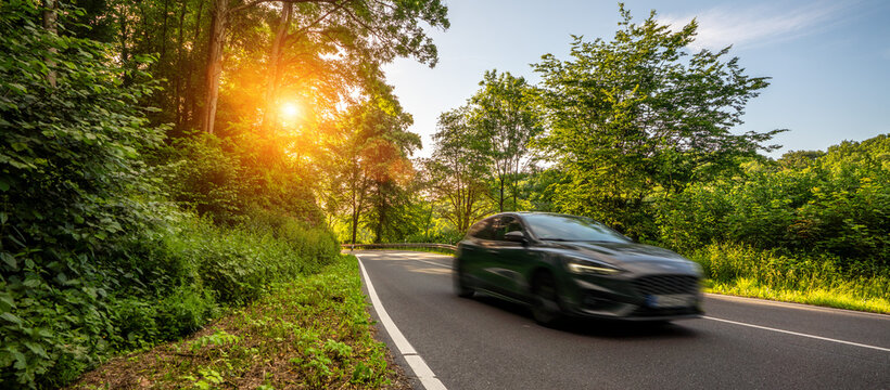 rental car in mountain landscape road at sunset