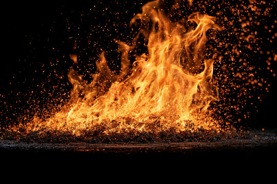 Burning orange fire with embers isolated on black
