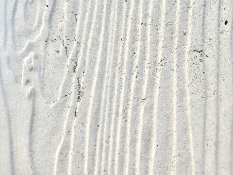 Macro view of a gray fiber cement building panel with distinct vertical grooved lines and an engineered wood texture pattern.