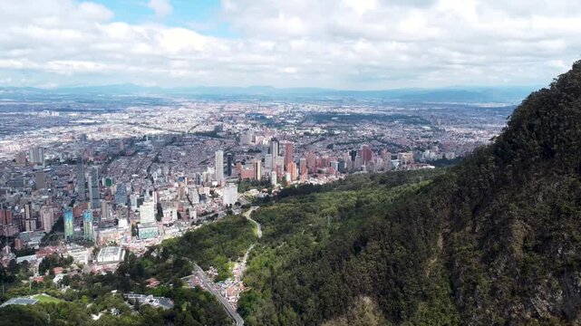 The drone flies above the city looking at the center of the city of Bogot&aacute; Colombia Aerial Material 4K mountains in the foreground near Monserrate