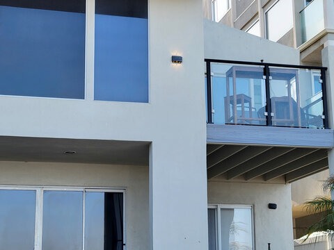 Modern balcony view with clean lines and glass details in bright early light over contemporary architecture