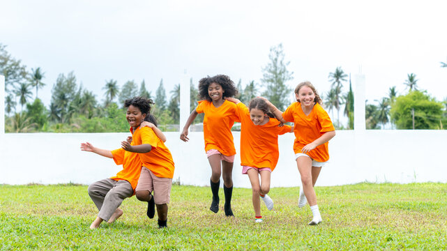 Group of Happy Diverse children kids playing outdoor school exercise together promoting active childhood teamwork friendship physical education healthy lifestyle fun recreation on grass playground