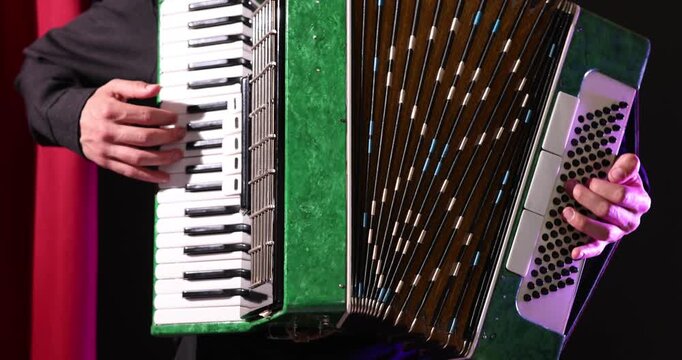 Man playing piano accordion on stage, closeup