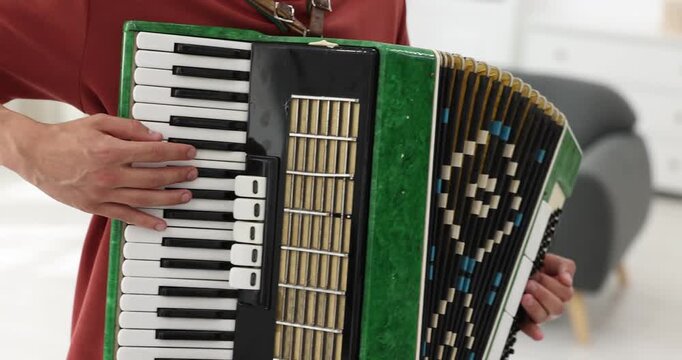 Man playing piano accordion at home, closeup