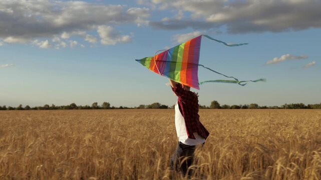 Boy running in the field, child playing with a kite, happy boy enjoying nature, kid running under the sunset, joyful child in the countryside, little boy holding kite, child running freely open field.