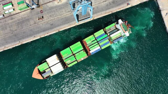 Aerial view of the container ship Veronica B, maneuvering for dock with a tug in the port of Alicante, in the Mediterranean coast of Spain.