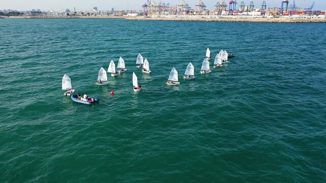 Aerial view of groupes of Optimist Class sailboats before the starting of a regatta in Alicante, in the Mediterranean coast of Spain.