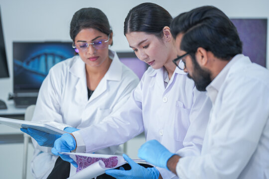 A diverse research team methodically carefully review laboratory specimen slides before molecular display screens as part of advanced scientific research using modern laboratory equipment.