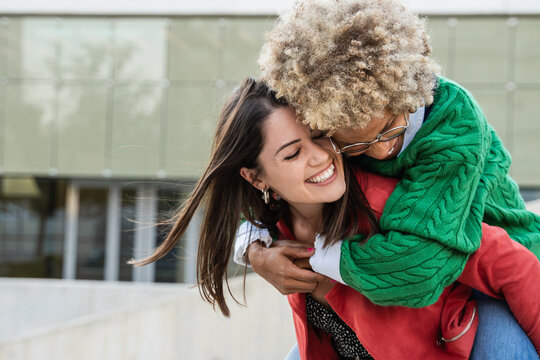 Happy gay lesbian couple having fun outdoors in the city. Diversity, LGBTQ and pride celebration concept