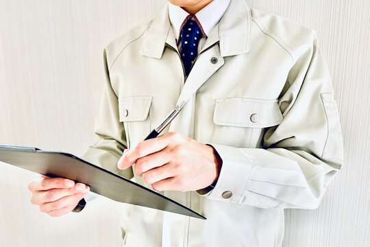 バインダーに書き込む男性スタッフ