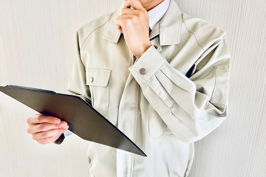 資料を見て考える男性作業員