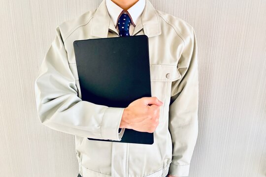 バインダーを持つ作業着の男性ビジネスマン