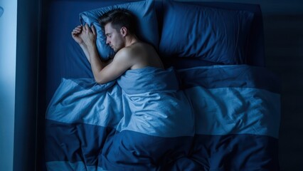 Obraz premium Man sleeping peacefully in dark bedroom, tranquil night rest, comfortable bed