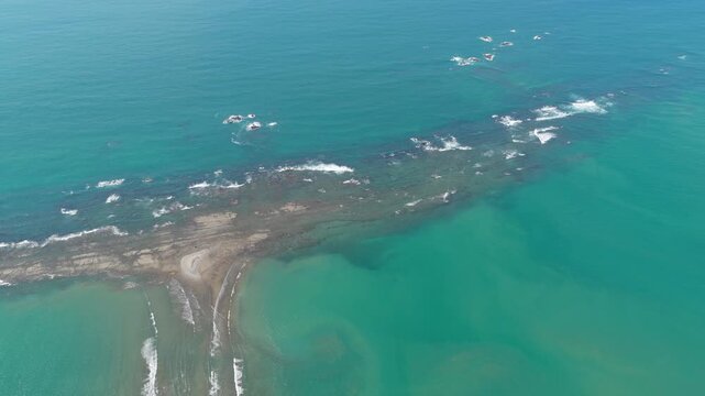 High altitude aerial view of the famous Marino Ballena National Park. Turquoise Pacific Ocean water surrounding the whale tail rock formation