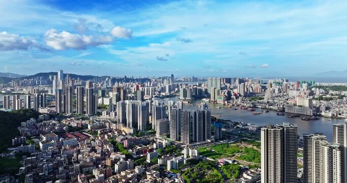 Aerial view of modern city skyline and waterway with ships in Macau, China