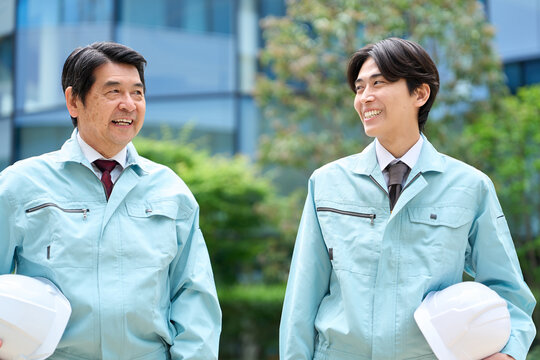 話をしながら歩くアジア人作業員の男性