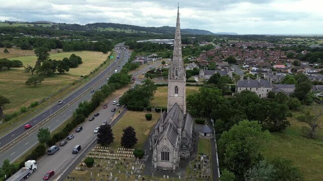 St Margaret's Marble church aerial view orbits neo gothic steeple overlooking Rhyl A55 motorway