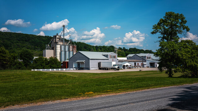 Tranquil New England summer road travel landscape with industrial factories and buildings along the highway through the Green Mountain National Park area in Middlebury, Vermont, USA