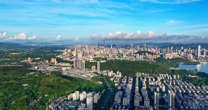 Aerial view of modern city skyscrapers surrounded by green mountains in Shenzhen, China