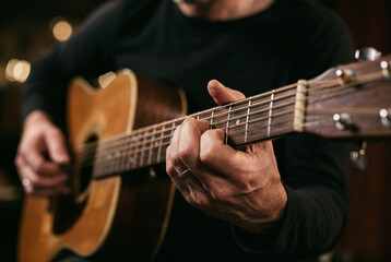 Obraz premium Close up of musician playing acoustic guitar in studio