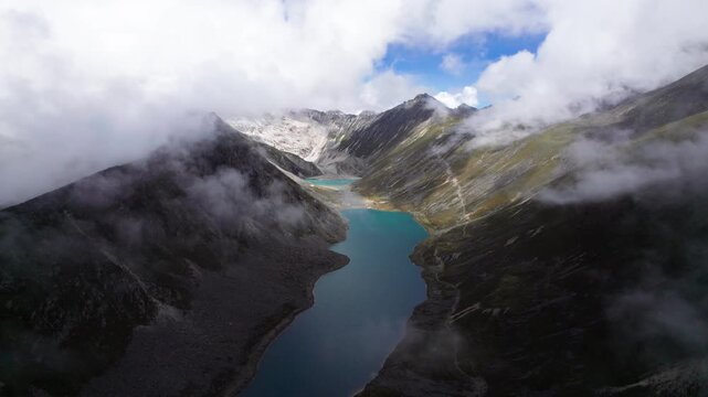 Drone view of Zhegong three lakes in Mount Kula Kangri in rainy sunny cloudy day, well-built hiking trail circling its shore. 4k hyper lapse footage travel concept b roll shot.