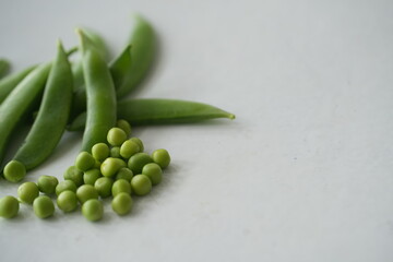 Fresh green pea pods arranged on a white background, highlighting natural freshness and healthy organic produce, ideal for food, agriculture, and cooking concepts © Kingsakai