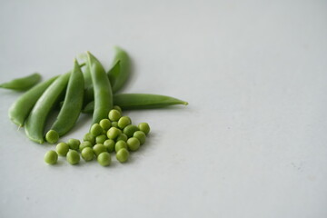 Fresh green pea pods arranged on a white background, highlighting natural freshness and healthy organic produce, ideal for food, agriculture, and cooking concepts © Kingsakai