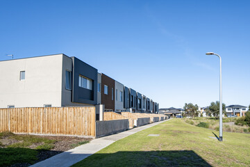 Fototapeta premium A row of modern, double-story terrace townhouses or medium-density residential housing units in a master-planned estate in an outer suburb of Melbourne, Victoria, Australia.
