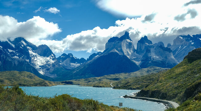 A scenic mountain road through the breathtaking landscape of Torres del Paine National Park, with turquoise waters and rugged peaks in Patagonia, Chile