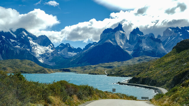 A scenic mountain road through the breathtaking landscape of Torres del Paine National Park, with turquoise waters and rugged peaks in Patagonia, Chile