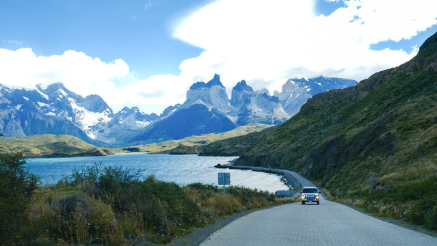 A scenic mountain road through the breathtaking landscape of Torres del Paine National Park, with turquoise waters and rugged peaks in Patagonia, Chile