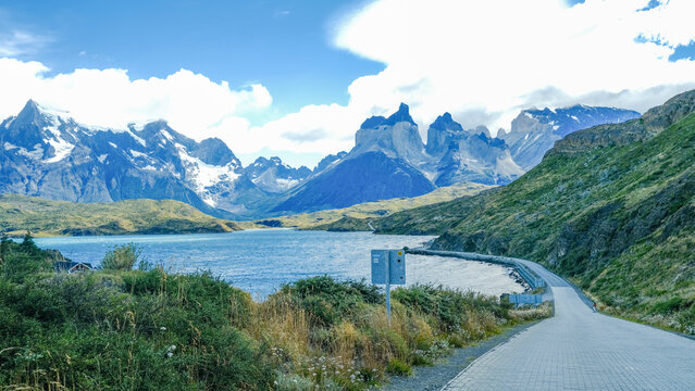 A scenic mountain road through the breathtaking landscape of Torres del Paine National Park, with turquoise waters and rugged peaks in Patagonia, Chile