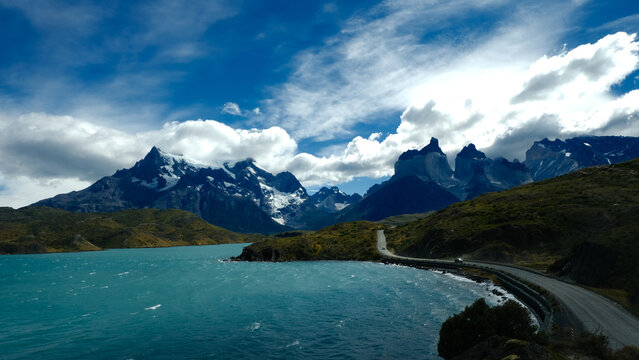 A scenic mountain road through the breathtaking landscape of Torres del Paine National Park, with turquoise waters and rugged peaks in Patagonia, Chile