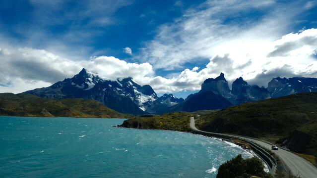 A scenic mountain road through the breathtaking landscape of Torres del Paine National Park, with turquoise waters and rugged peaks in Patagonia, Chile