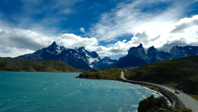 A scenic mountain road through the breathtaking landscape of Torres del Paine National Park, with turquoise waters and rugged peaks in Patagonia, Chile