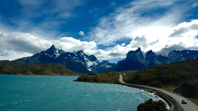 A scenic mountain road through the breathtaking landscape of Torres del Paine National Park, with turquoise waters and rugged peaks in Patagonia, Chile