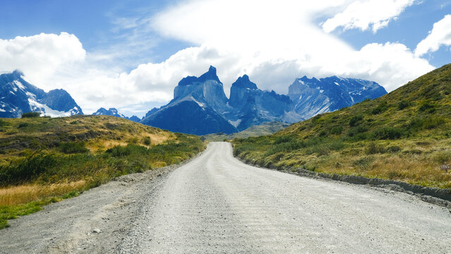 A scenic mountain road through the breathtaking landscape of Torres del Paine National Park, with turquoise waters and rugged peaks in Patagonia, Chile