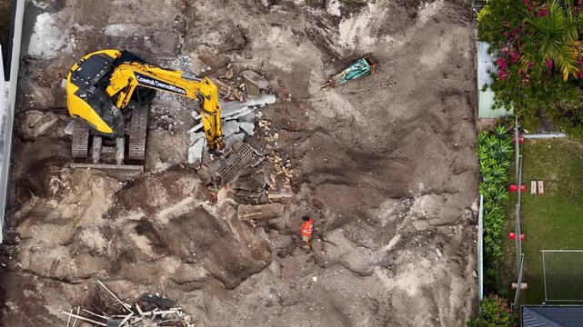 Aerial View of Yellow Excavator Clearing Concrete Debris on Construction Site