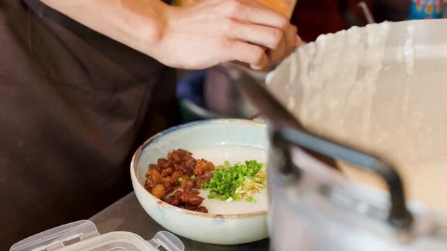 Chef Preparing Traditional Asian Pork Congee at Street Food Stall