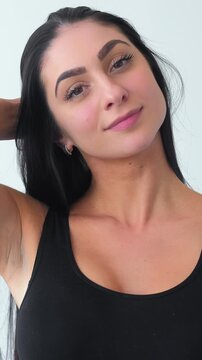 Vertical video. Wellness portrait. Smiling model. Young woman demonstrating long hair pretty face skin. Natural charm young beauty.