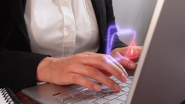 Files verified and protected. Close-up of a businesswoman's hands working on her computer with a virtual folder icon and a shield containing a checkmark.