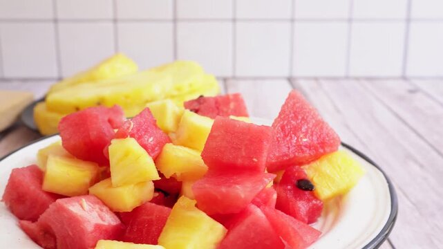 Fresh watermelon and pineapple chunks fill a white plate. Bright red and juicy yellow pieces show summer freshness. Ideal for food blogs