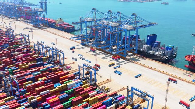 Aerial drone view of Qingdao fully automated smart container port, unmanned intelligent dock with automated cranes and container stacks for global shipping logistics。