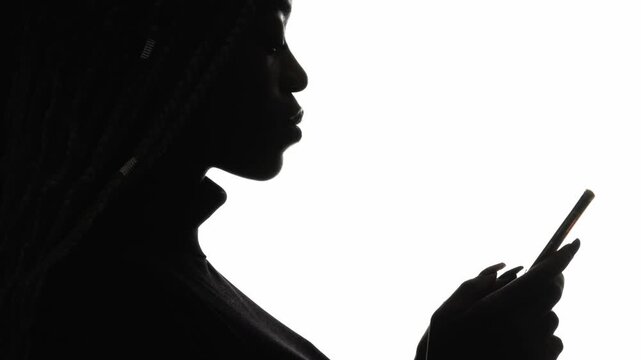 Mobile network. Chatting silhouette. Internet communication. Profile of confident woman scrolling feed using phone isolated on white copy space background.