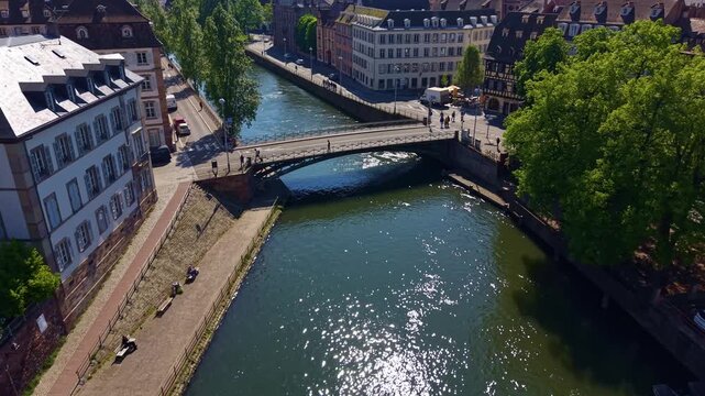 Pont Saint-Thomas crosses the Ill River below &Eacute;glise Saint-Thomas in Strasbourg, Bas-Rhin, Grand Est, Alsace, France, linking the UNESCO Grande &Icirc;le with its historic waterfront, drone forward flight.
