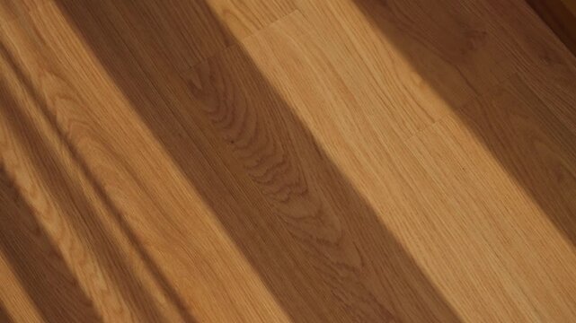 Shadow from window and curtain created on wooden floor as wind blows fabric. Romantic peaceful cozy scene. Texture and pattern. Apartment or house with modern parquet during morning or sunset light