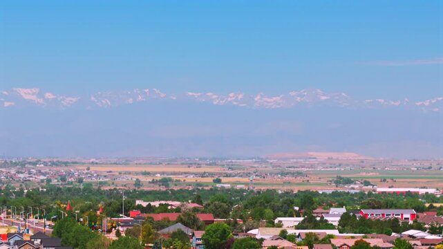 Brighton Greeley Lafayette Erie Colorado aerial drone December spring summer sunny morning blue sky Front Range foothills cars building neighborhoods home Aurora North Ft Collins pan