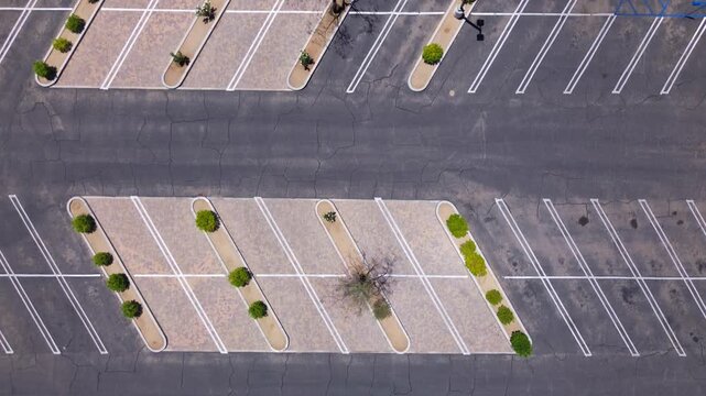 Completely empty shopping mall parking lot seen from birds-eye drone view. Midday in summer. Diagonal parking lot lines. No cars or pedestrians.