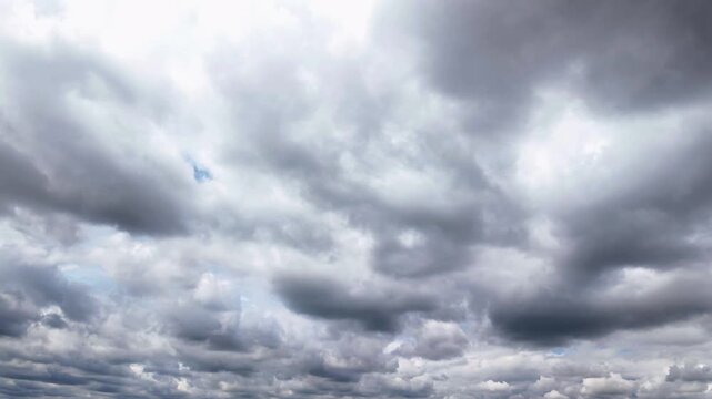 A dynamic timelapse of dark, dramatic gray clouds moving across a bright blue sky, creating a powerful and atmospheric scene.